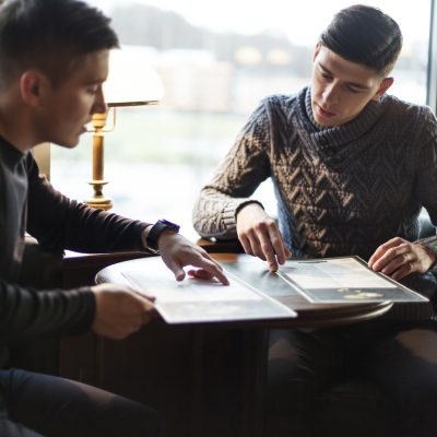 men-choosing-food-cafe-together